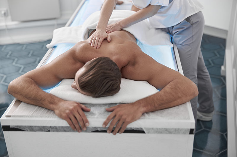 persona haciéndose un masaje, un tipo de terapia alternativa